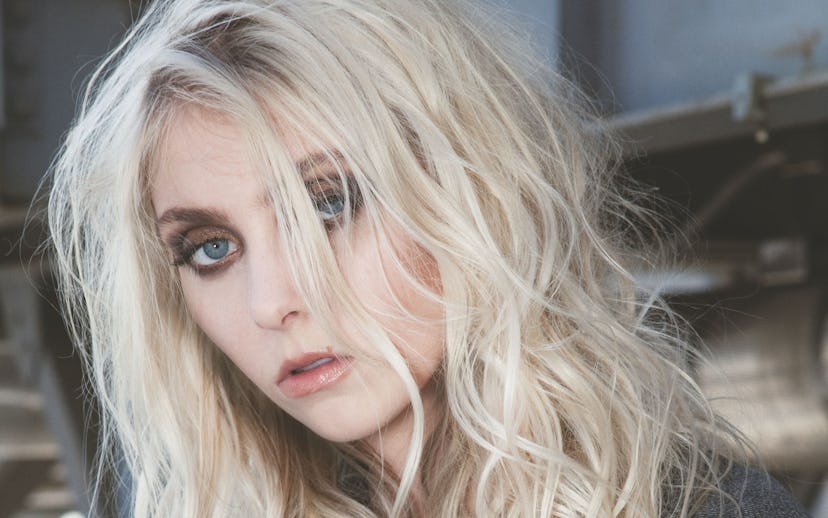 Taylor Momsen in a dark denim jacket, with messy, blond hair, and dark eye make-up, wearing jewelry ...