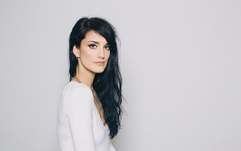 Young Summer in a white, long-sleeved V-neck shirt and a thick gold necklace