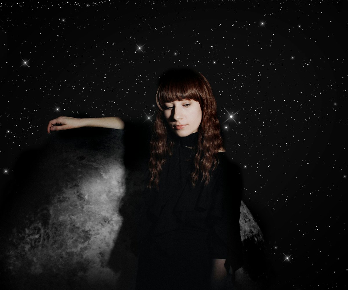 Singer Emily Reo posing on a galaxy background while breaking down notions of normativity in music.