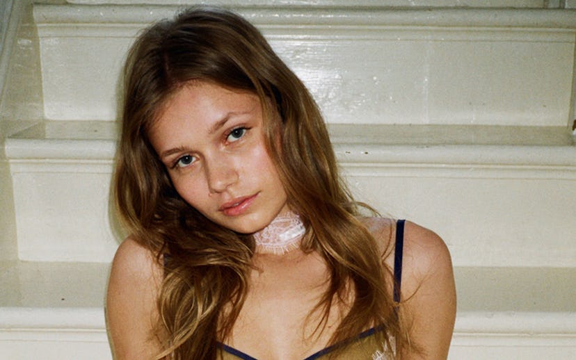 A brunette model posing in an Edie bra, choker, and Edie knicker by Dora Larsen