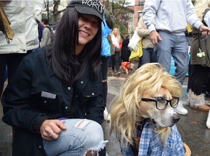 A dog in a blonde wig and glasses with its owner at the NYC Dog Halloween Parade 
