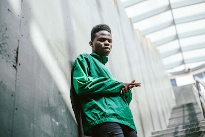 Daye Jack posing in a green jacket