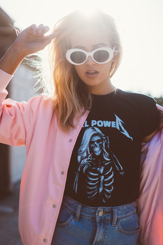 A blonde woman wearing a black t-shirt and pink jacket from NYLONshop and Petals and Peacocks collab...