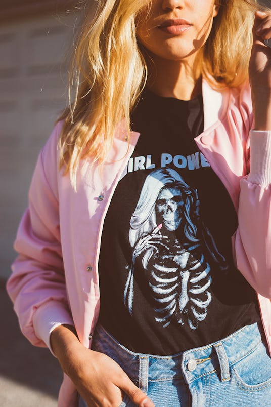 A blonde woman wearing a black t-shirt and pink jacket from NYLONshop and Petals and Peacocks collab...