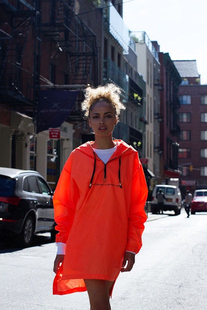 A model wearing the Tastemaker Collective orange windbreaker jacket