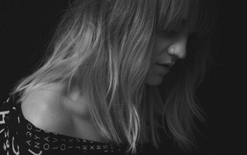 A blonde girl with a nose piercing in a black and white picture
