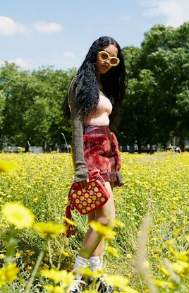 A model in a red furry skirt that matches the red coin shoulder bag by Poppy Lissiman