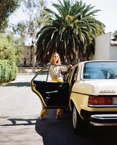 Lexi Stellwood posing next to her 1982 Mercedes-Benz