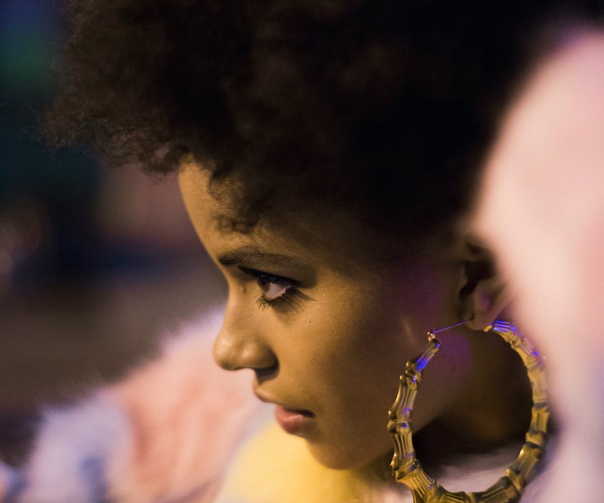 Actress Zazie Beetz in a pastel pink faux-fur coat and large golden pirate earrings