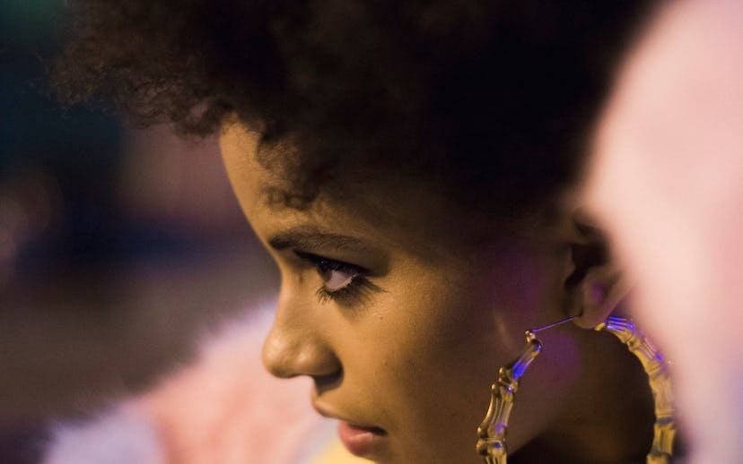 Actress Zazie Beetz wearing a pastel pink faux-fur coat and large golden pirate earrings