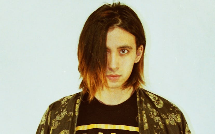 Cullen Omori looking straight at the camera in a black tee and dark green Kimono