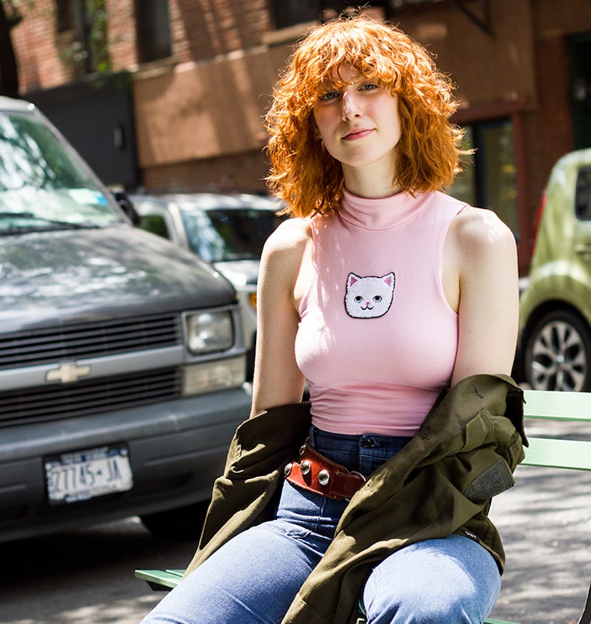 Sunkissed Claire Geist  in a pink cropped turtleneck with a cat on it and a pair of jeans