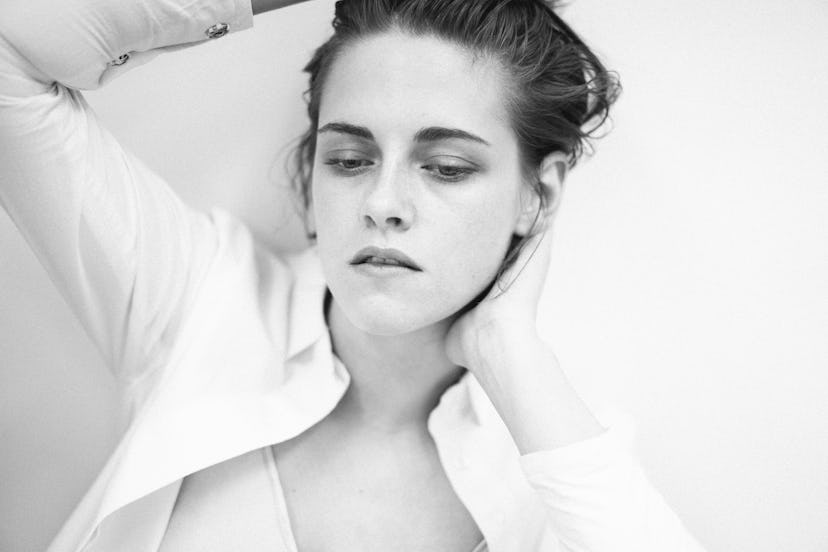Kristen Stewart with her eyes closed in a white button up shirt