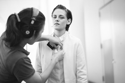 A sound woman putting a microphone on the shirt of Kristen Stewart 