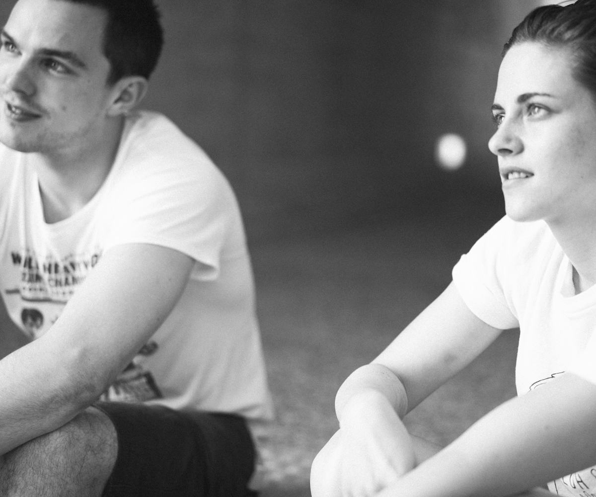 Nicholas Hoult and Kristen Stewart sitting on the ground 