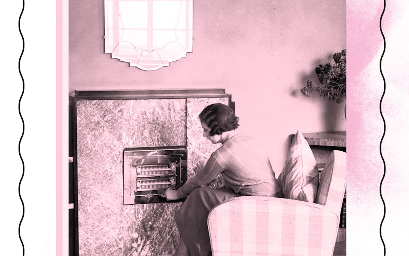 A woman sitting on an armchair next to a fireplace in her living room 