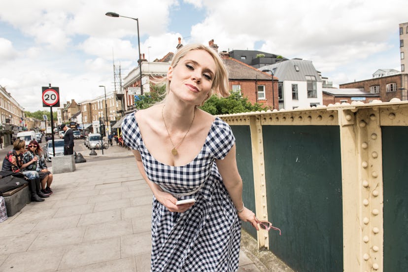 Kate Nash posing for a photo in the street, in a checkered dress