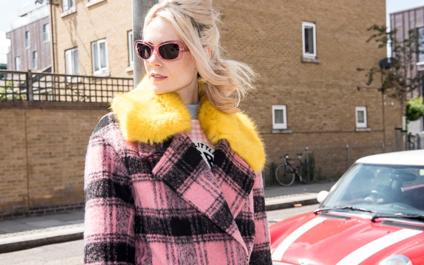 Kate Nash in a pink-and-black checkered coat with a yellow fur collar and pink shades.