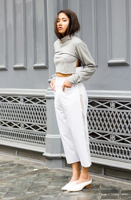 A girl in a grey shirt and white pants