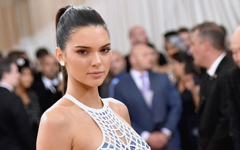 Kendall Jenner on the red carpet in a white dress with a web pattern