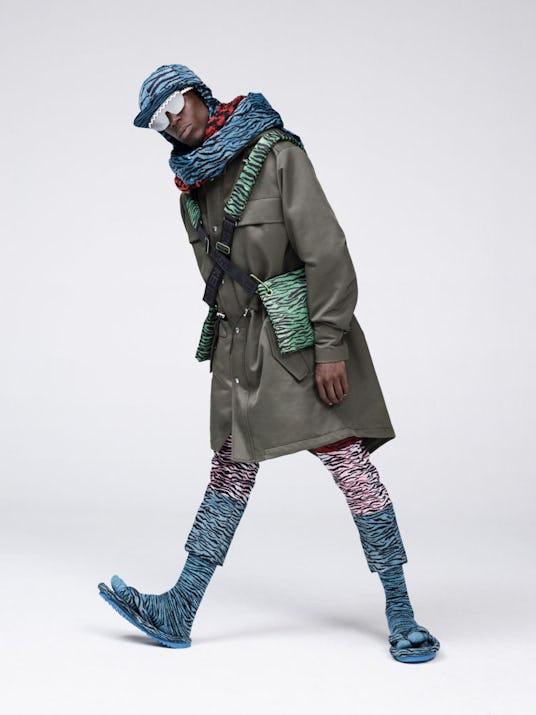 Oko Ebombo in an Kenzo x H&M outfit consisting of a blue hat and matching scarf, a leather coat and ...