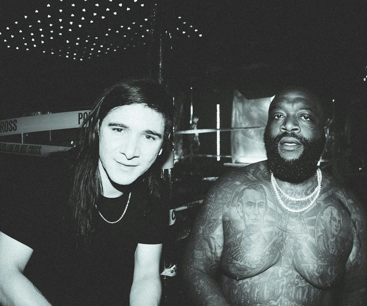 Skrillex in a black shirt with a chain necklace and shirtless Rick Ross with two chain necklaces 