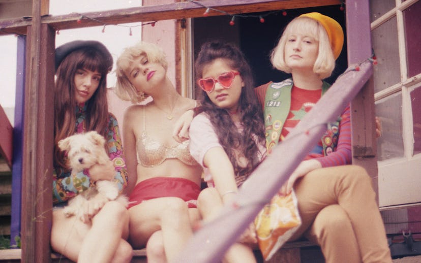 Girl group Ruby the RabbitFoot, sitting on a porch in colorful outfits