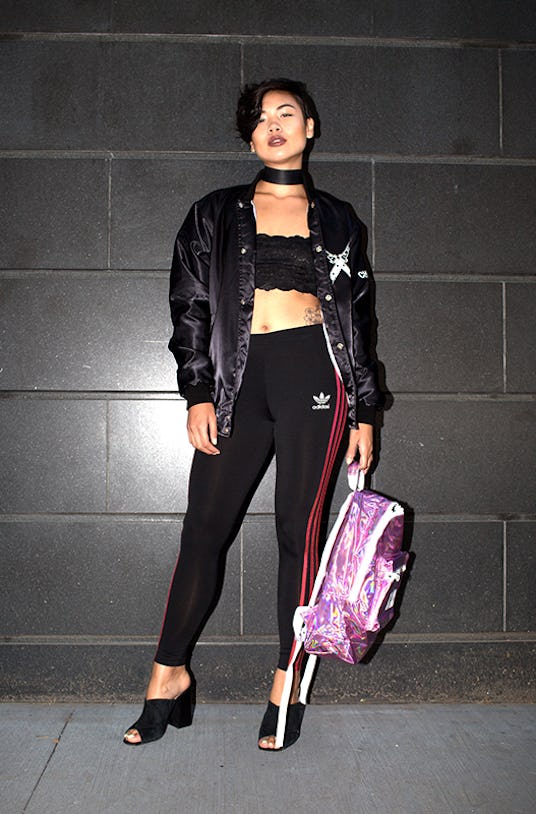 Lynn Kim wearing black leggings, a black top, and a black jacket while holding a pink backpack