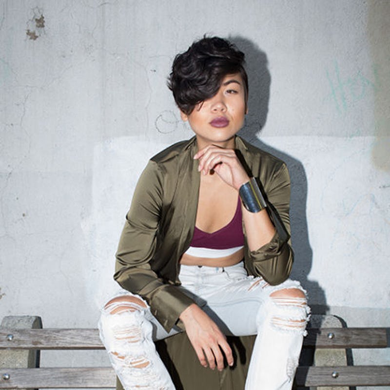 Lynn Kim in light ripped jeans, a burgundy top and an olive jacket