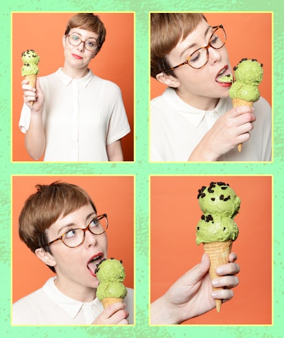 A woman with short hair and red lipstick eating a green ice cream cone