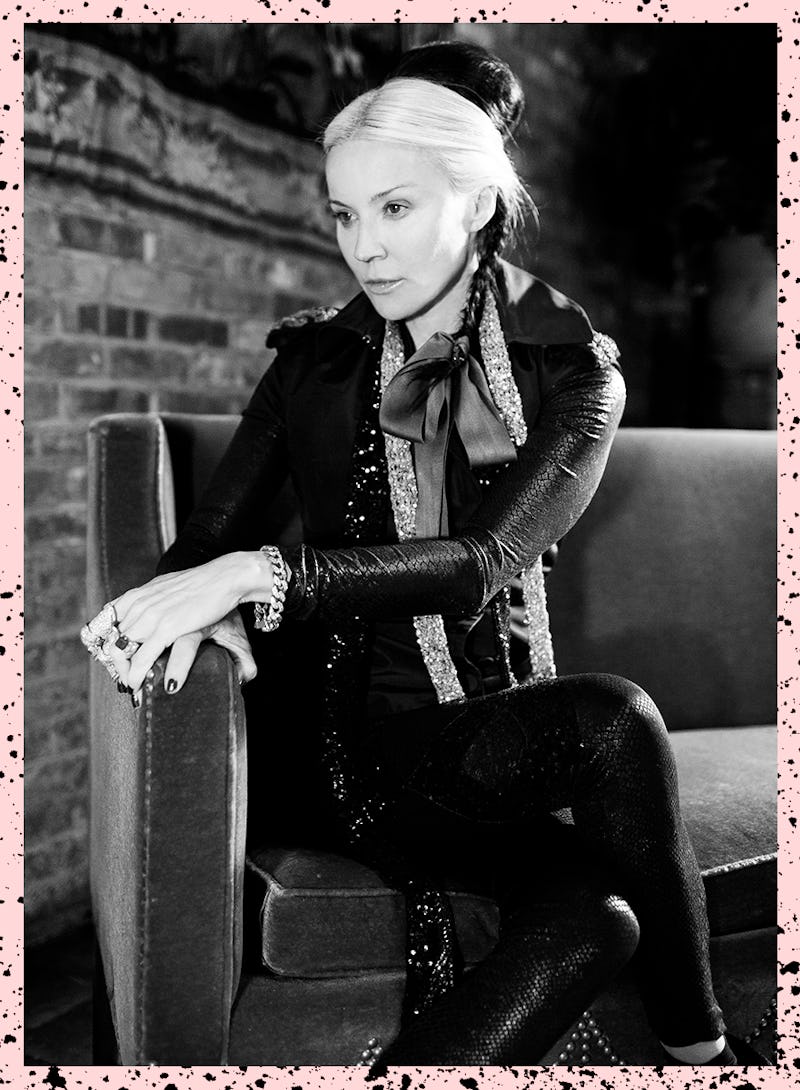 Daphne Guinness sitting on a couch while wearing an all black outfit with sequin accents 