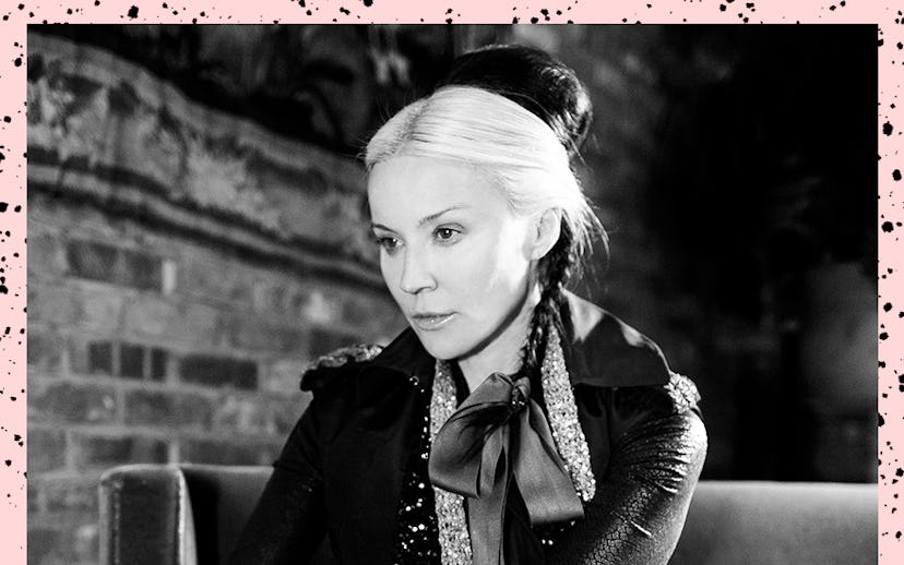 Daphne Guinness sitting on a couch while wearing an all black outfit with sequin accents