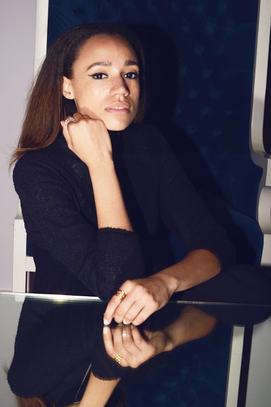 JONES, London-based singer-songwriter in an all black outfit with her hand on a mirror table