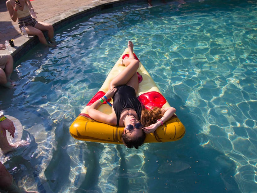 A girl lying on a pizza float in the water