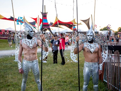 Two men in silver pants and armor, silver crowns on their heads, and silver wings attached to their ...