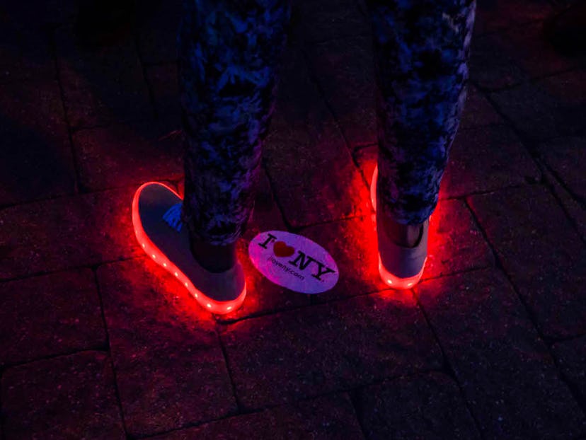 White shoes with light-up soles shining in red