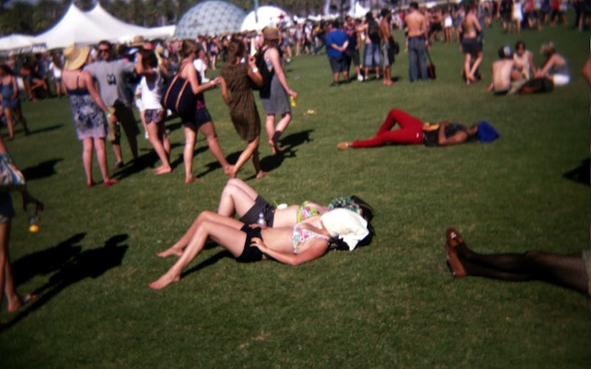 Music festival in the open with lots of people relaxing on the grass