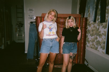 Two blonde women wearing vintage cutoff shorts and hand signalling that they like them