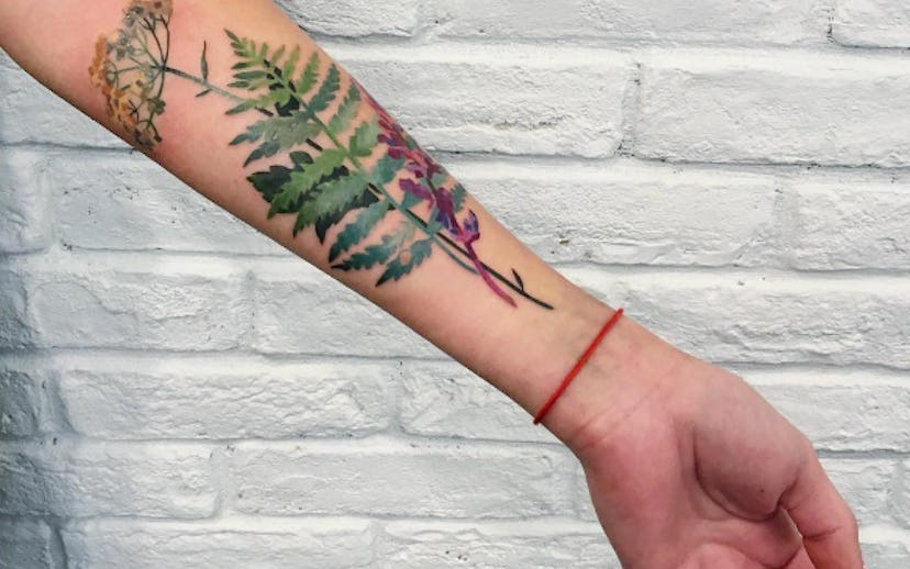 Green fern tattoo on a left hand
