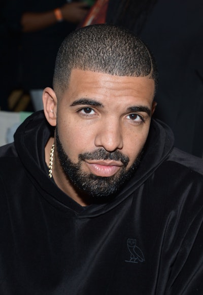 Drake wearing a black hoodie and a golden chain around his neck 