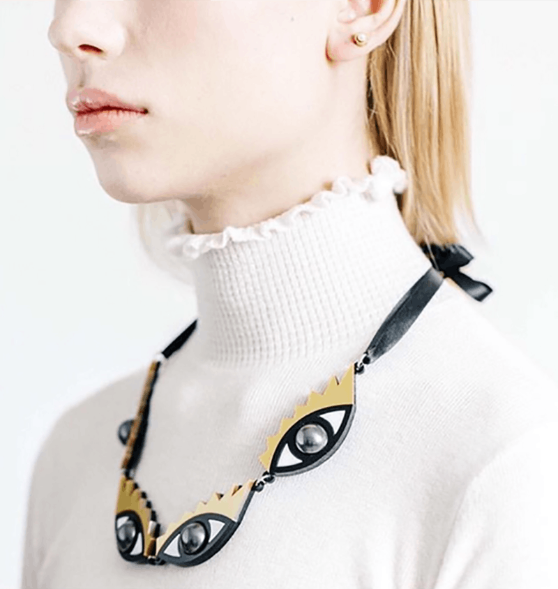 A model with an eye inspired necklace around her neck