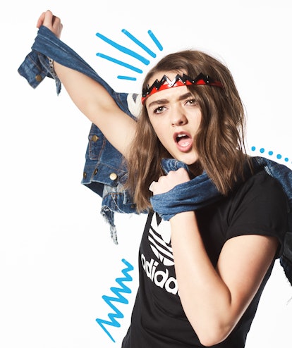 Maisie Williams with her hand stretched out with a denim jacket behind her back, top by Adidas Origi...