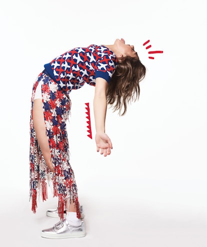 Maisie Williams bending over backwards in a blue and red sweater by Chanel, skirt by Marc Jacobs, sh...