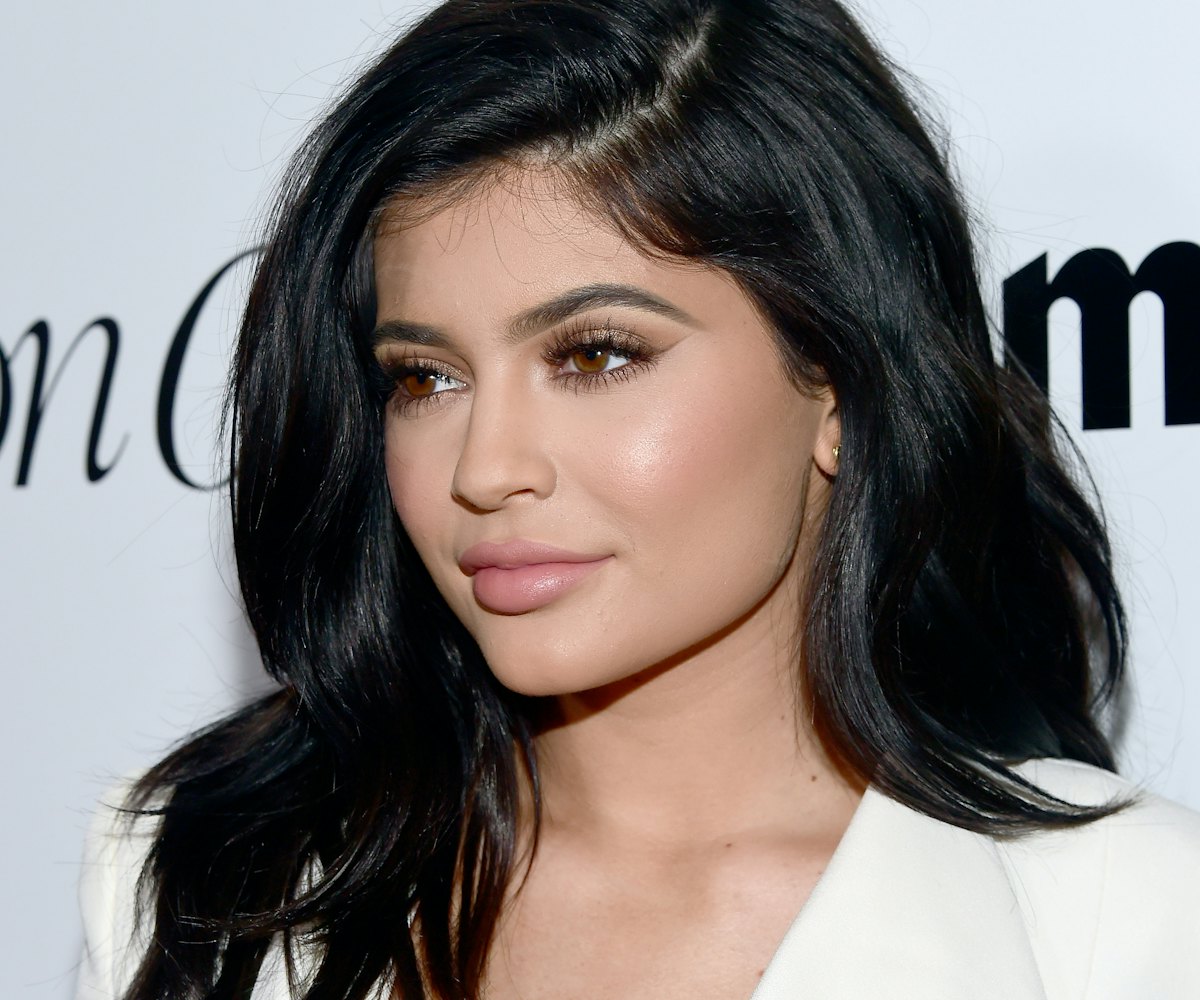 Kylie Jenner posing for paparazzi with a natural makeup look.