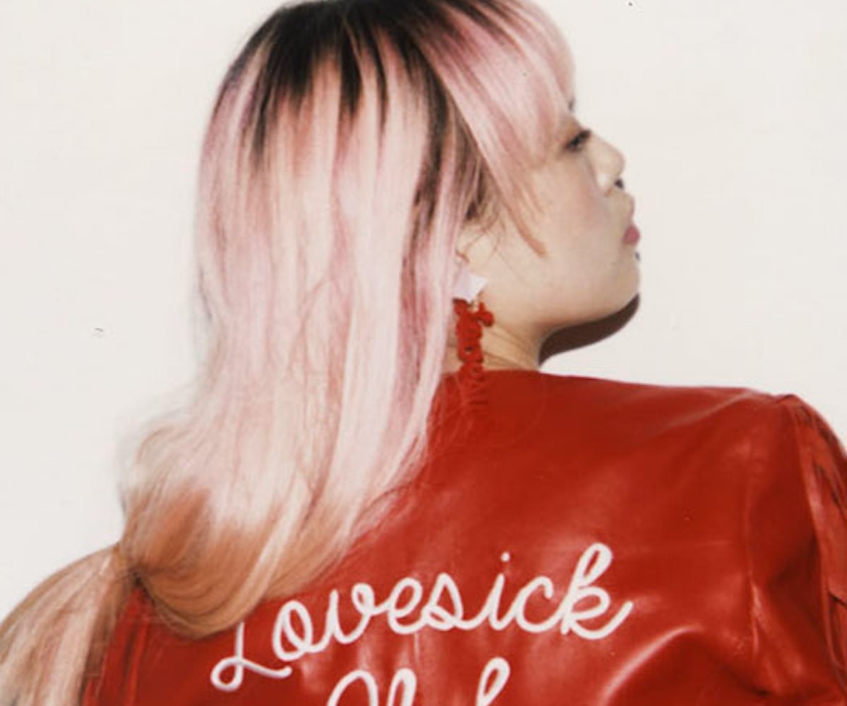 Missy Skins, a fashion designer, posing in a red leather jacket that says "Lovesick Club".