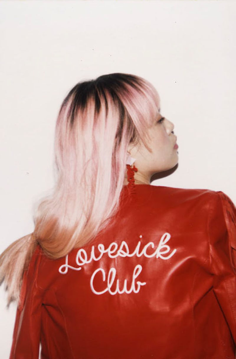 Missy Skins, a fashion designer, posing in a red leather jacket that says "Lovesick Club"