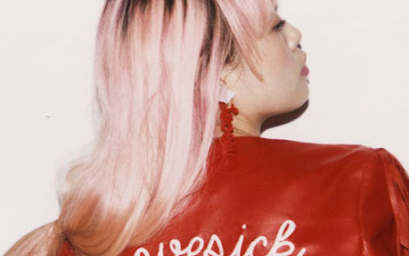 Missy Skins, a fashion designer, posing in a red leather jacket that says "Lovesick Club"
