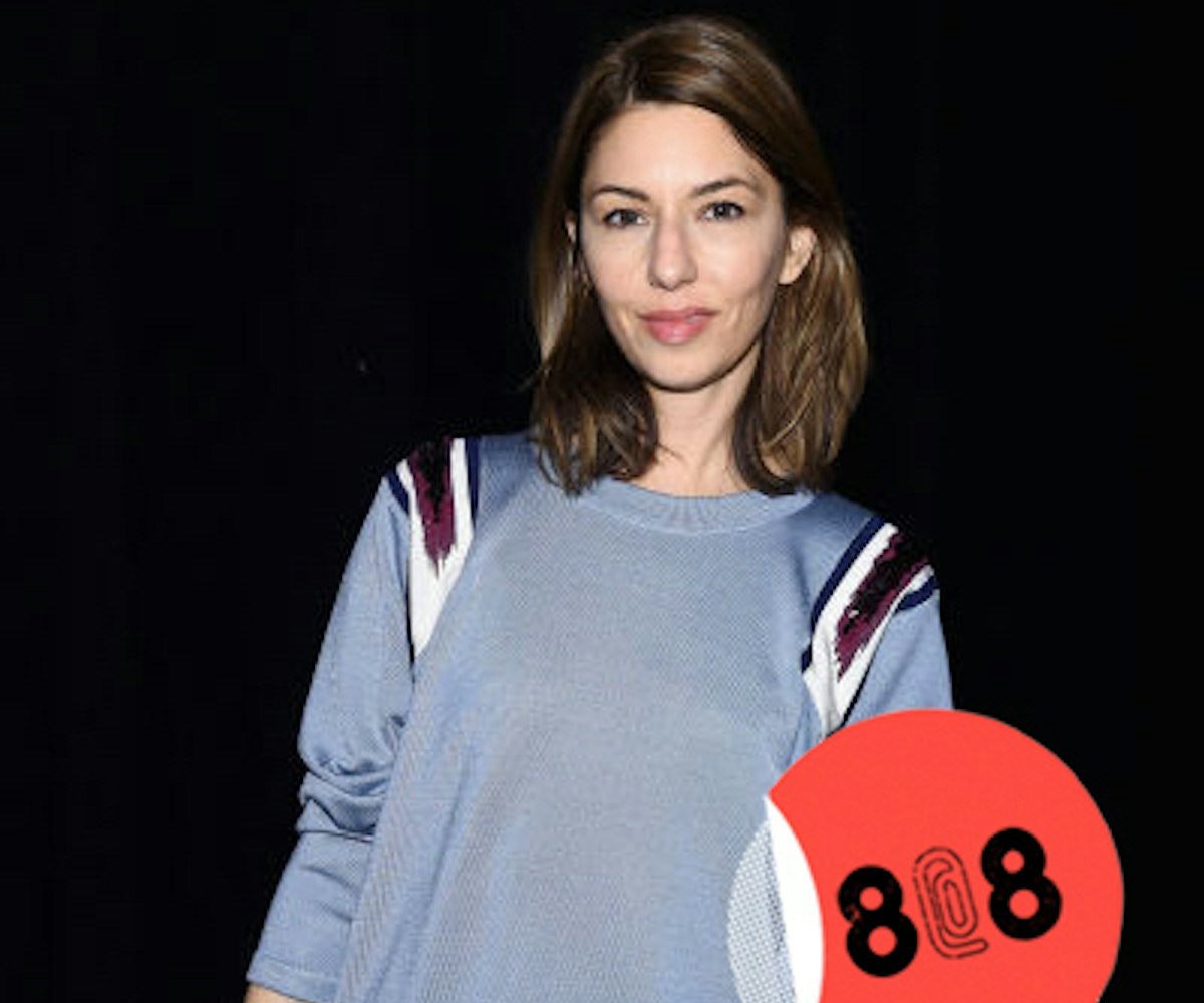 Sofia Coppola in a grey shirt with burgundy and white stripes on the shoulders