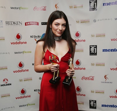 Lorde posing with the awards that she had won, after doing a tribute to David Bowie at the Brit Awar...