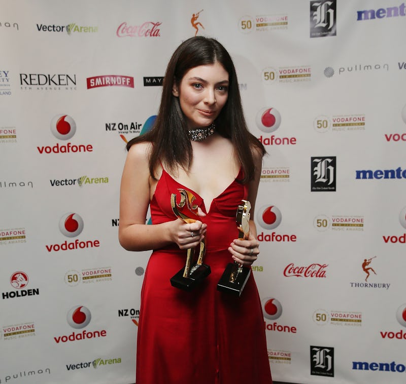 Lorde posing with the awards that she had won, after doing a tribute to David Bowie at the Brit Awar...